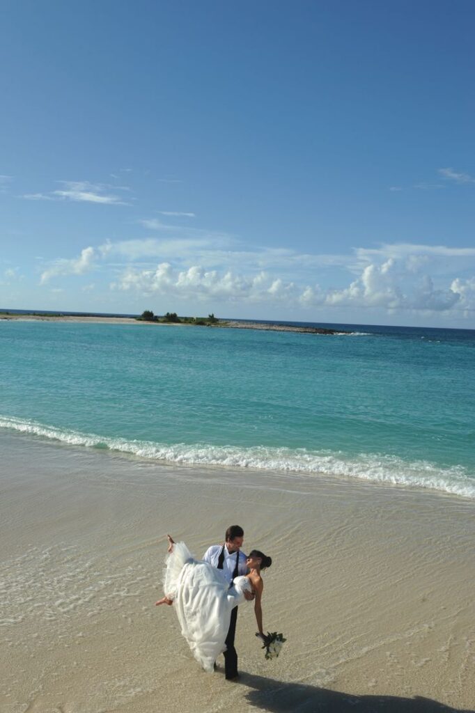 Bride carried by her groom at a beach in the Bahamas