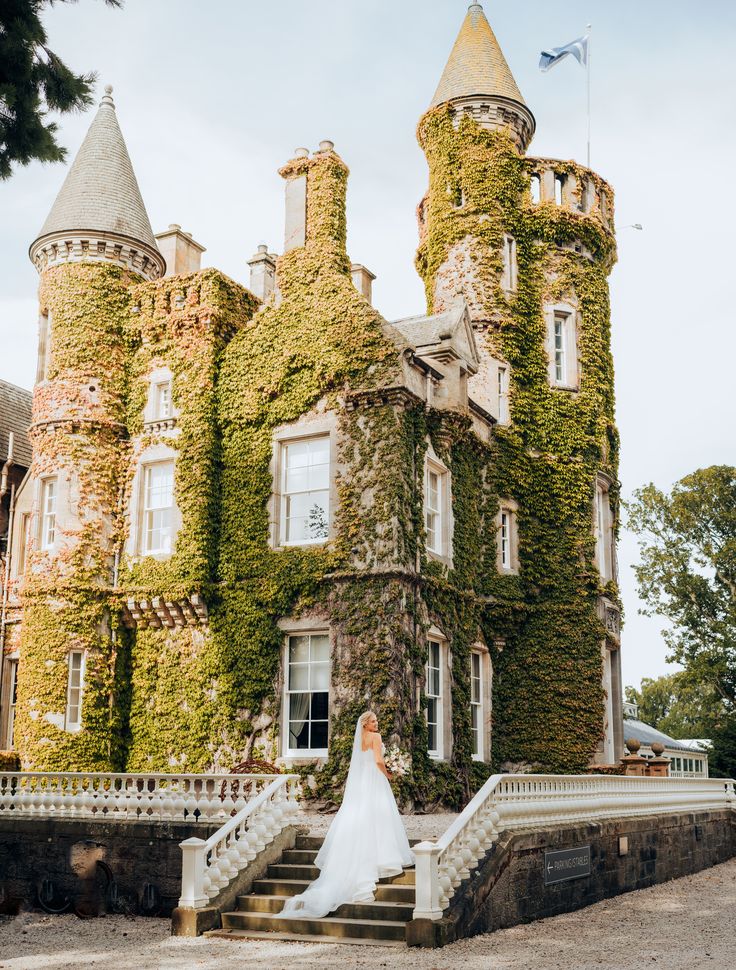 Bride standing on the stairs of the Carlowrie Castle in Scotland, one of the choicest destination wedding locations in Europe