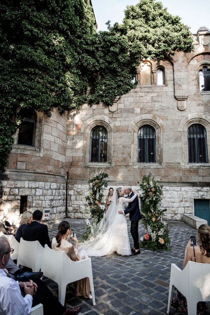 Bride and groom locked in a kiss at their wedding in Vajdahunyad Castle, Budapest, Hungary