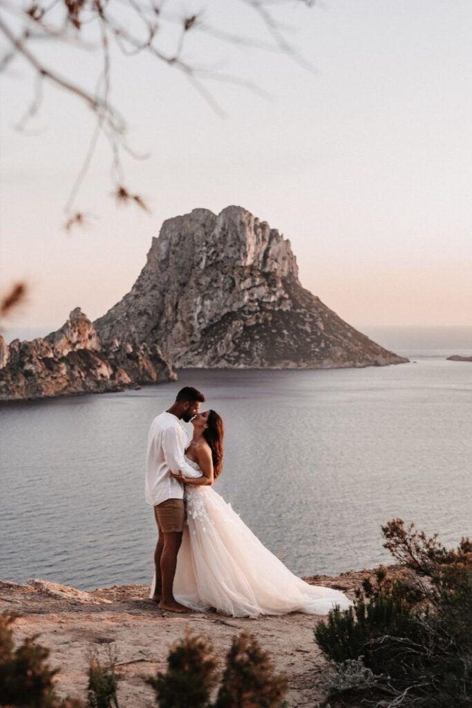 Couple kissing in front of beach overlooking Ibiza Mountain