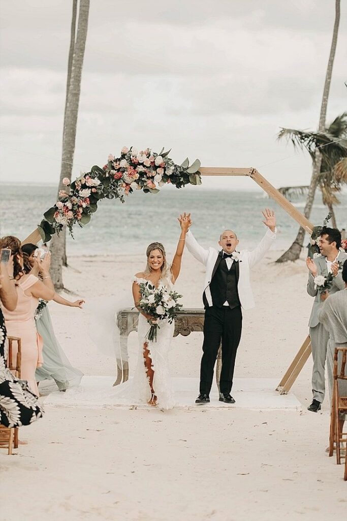 Happy couple surrounded by friends at wedding on Grace Bay Beach, Turks and Caicos