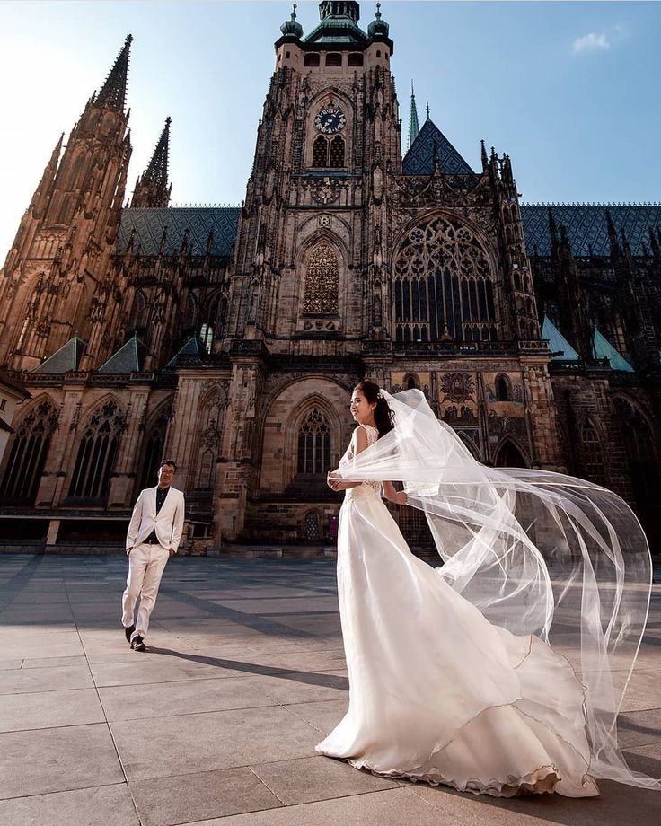 Couple standing in front of the St. Vitus Cathedral located within the Praque Castle